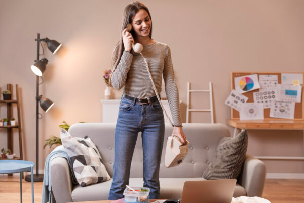 Long shot of woman talking on an old telephone